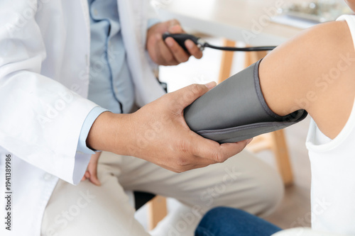 Doctor Measuring Patient Blood Pressure in Clinic.