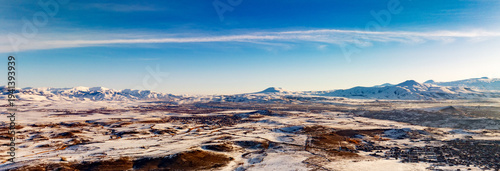 Banner with copy space. A clear blue sky with a few clouds and a snowy landscape