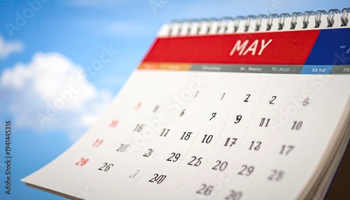 A close-up of a calendar for May against a bright blue sky