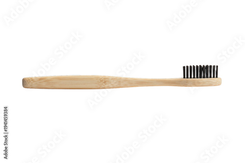 Eco-friendly bamboo toothbrush with black charcoal bristles lying flat, sustainable oral care product isolated on transparent background cutout.