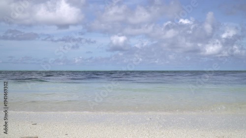 The sea coast of a tropical island, a sandy beach without people, a calm, clear sea on a sunny day.