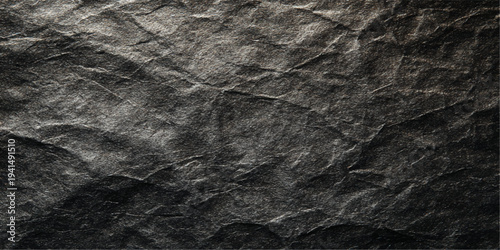A dark grunge black fabric texture and wrinkled paper surface with a rough crumpled pattern on a vintage gray material background
