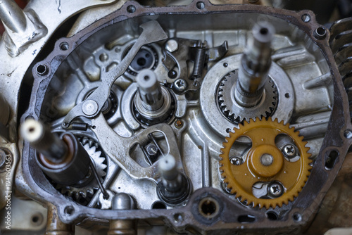 Detailed close up of an open motorcycle engine gearbox, showing complex metal gear mechanism and machinery. inside view of transmission reveals parts for repair