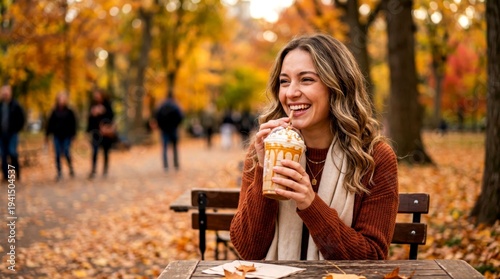 Woman enjoying caramel flavored drink in autumn park surrounded by colorful fall leaves celebrating cozy seasonal dessert beverage moment