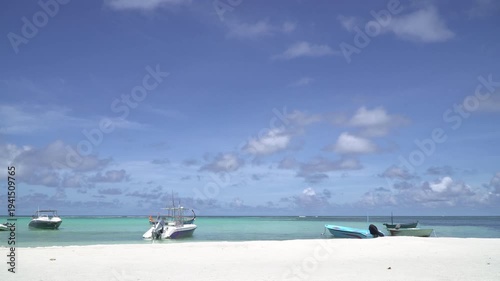 Maldives, clear blue sea, sandy beach, fishing and pleasure boats off the coast