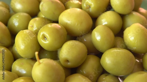 Green olives glossy fruit close up top view, food background