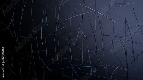 Close-up of a scratched, dark, reflective surface with subtle undulations