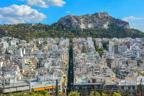 View over central Athens, Greece, with dense residential districts and apartment blocks leading toward Lycabettus Hill rising above the city skyline