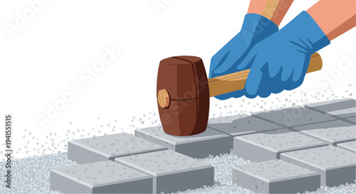 Hands wearing blue gloves are precisely using a brown rubber mallet to tap down grey square paving stones onto a bed of gravel.