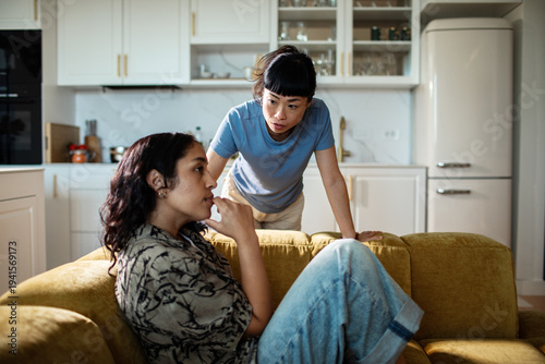 Two women having a serious conversation at home in the kitchen