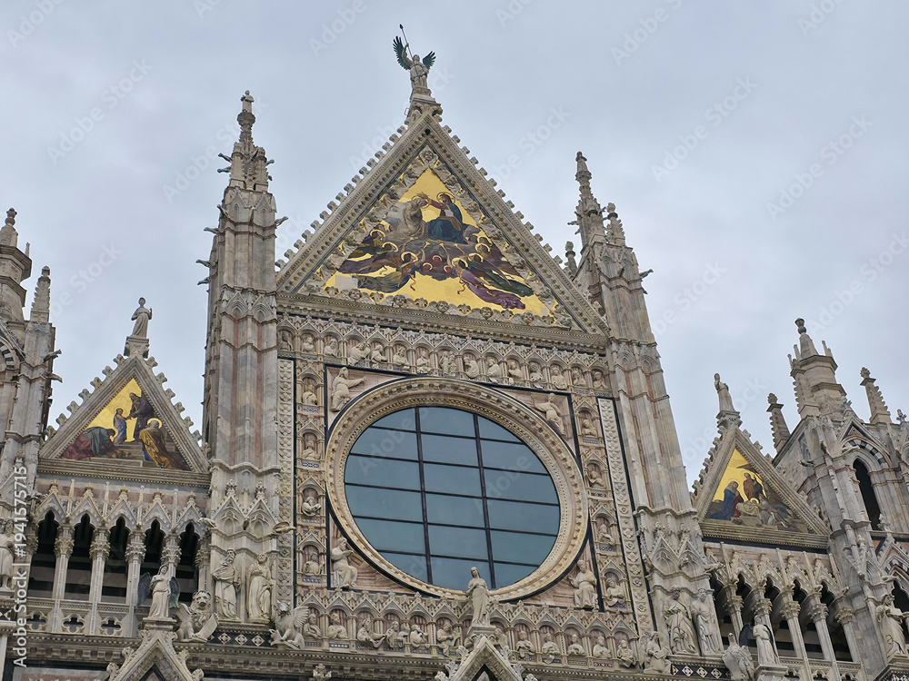 Fototapeta premium Siena Cathedral facade detail with ornate Gothic sculptures, rose window and golden mosaics in Tuscany, Italy