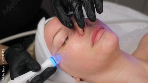 Cosmetologist performing a professional skin cleansing and rejuvenation procedure on a client's face