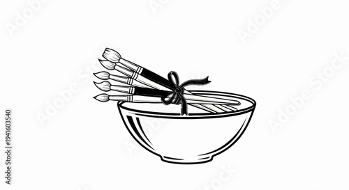 A bundle of paintbrushes tied with a ribbon sits in a bowl