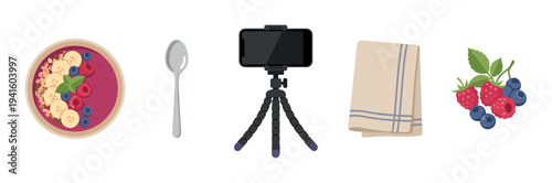 Food vlogging and photography essentials collection with a berry smoothie bowl, smartphone on a flexible tripod, spoon, napkin, and fresh fruit for a healthy breakfast recipe