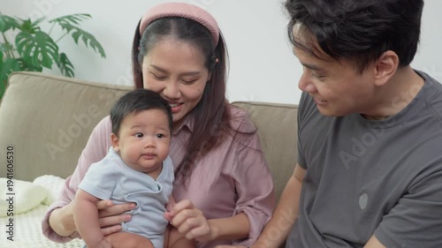 Loving family moment: Capturing a heartwarming scene of a young family. A mother and father gently cradle their baby, cherishing an intimate connection and the joys of parenthood.