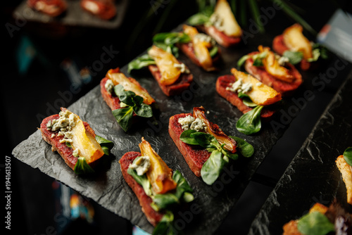 Gourmet beet and pear appetizers with blue cheese on slate trays