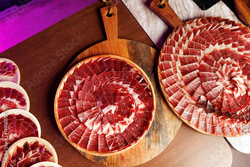 Table with various platters of sliced Jamon Iberico for catering