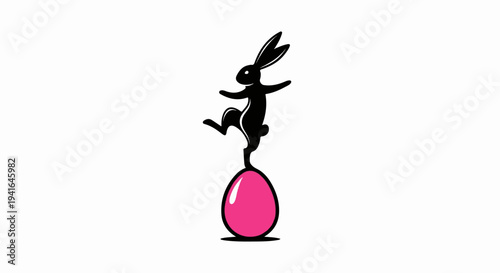 Black rabbit balances on a pink egg, poised and playful