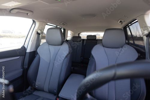 Interior of new modern clean expensive car. Passenger seats with leather. Closeup details. New electric car inside. Car cleaning theme. Luxury car rear leather seats row