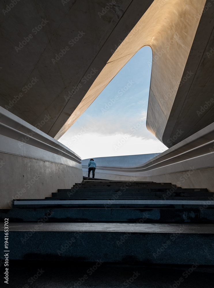 Fototapeta premium Person walking up in the stairs towards open bright space. The way forward. Personal targets achievement