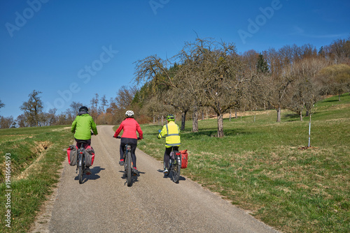 Group of active senior women enjoying a bicycle tour on a sunny spring day in the Swabian Forest, Germany. Friends cycling together through nature, promoting healthy lifestyle, recreation, and outdoor
