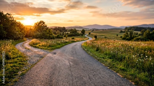 Forked country road at sunset symbolizing life decisions business direction and strategic career choice with long perspective copy space