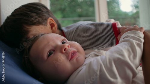 Obraz na plátně Older brother kissing baby intensely, affectionate yet overwhelming sibling mome