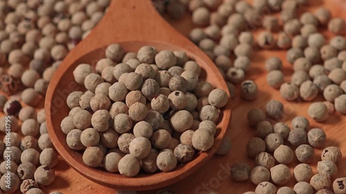 white peppercorns in the wooden spoon