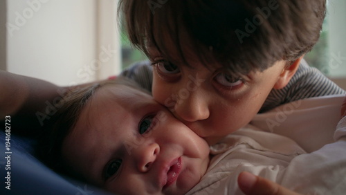 Canvas Print Older brother kissing baby intensely, affectionate yet overwhelming sibling mome