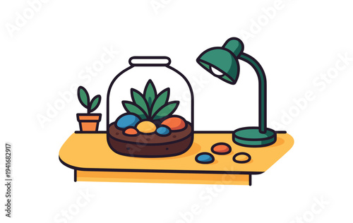 A tabletop scene showing a glass terrarium with a succulent and colorful round stones, a small potted plant, and a green desk lamp on a yellow surface for home decor or workspace designs.