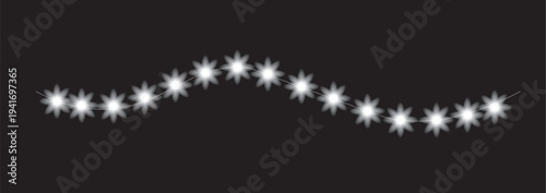 A wavy line of white starburst lights on a black background