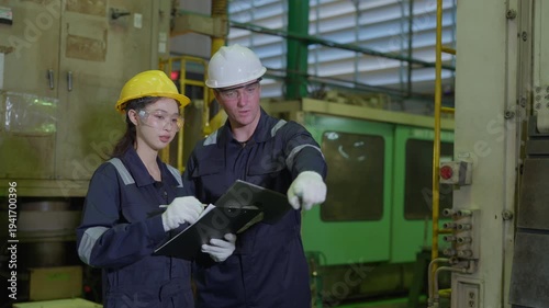 Diverse engineers factory workers holding clipboard and digital tablet checking production quality control. Technician team wearing safety equipment discussing project in industrial warehouse