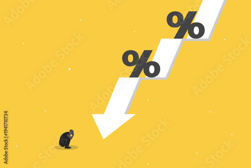 Businessman crouching in despair at a falling downward arrow with percent symbols, representing falling interest rates, deflation, and recession