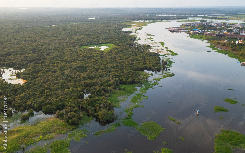 Fototapeta premium High-resolution aerial drone view of the riverside community of Barrio de Belén in Iquitos, showing houses built along flooded wetlands and a traditional boat navigating through the water channels