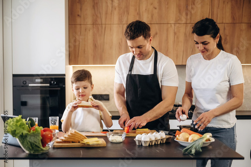 Photos Family cooking together in a modern kitchen, a man and woman prepare vegetables
