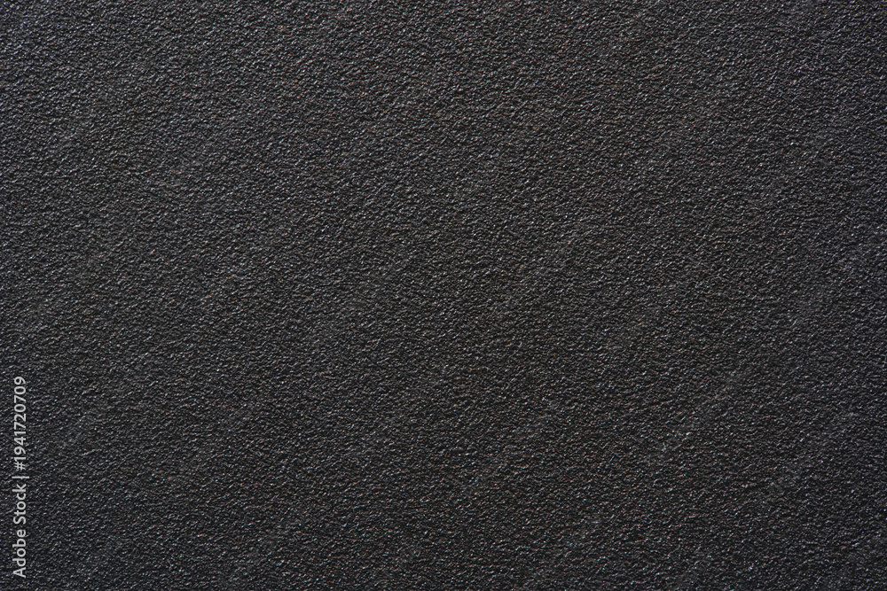 Fototapeta premium Black textured plastic surface background full frame top view of rough matte electronics casing material, dark abstract backdrop wallpaper technology design template, high resolution detail, no people