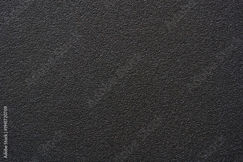Black textured plastic surface background full frame top view of rough matte electronics casing material, dark abstract backdrop wallpaper technology design template, high resolution detail, no people