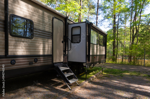 Lake below a camper trailer in a forested campsite
