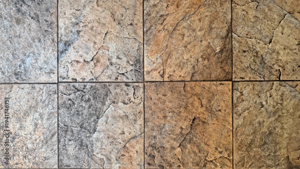 Obraz premium Top-down view of textured beige and grey ceramic floor tiles mimicking natural stone clefts.