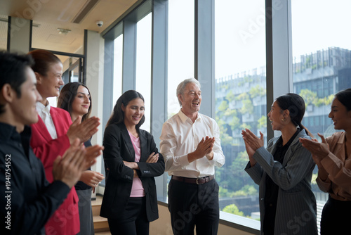 Obraz na plátně Diverse business team applauding and celebrating success in a modern office sett