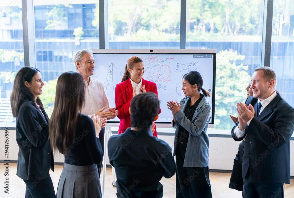 Fototapeta premium Diverse business team applauds success during a modern office meeting with whiteboard presentation