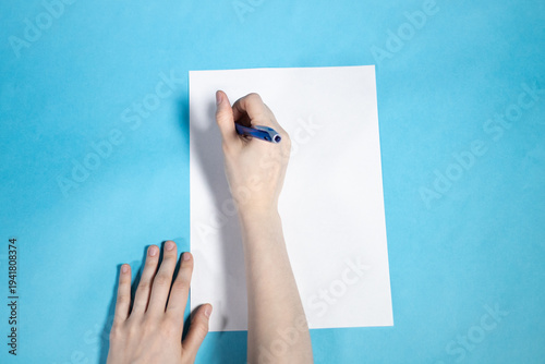 top view of hand writes on blank white paper