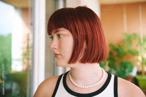 Cuadro en lienzo Side profile portrait of teenage girl with red hair and pearl necklace looking a