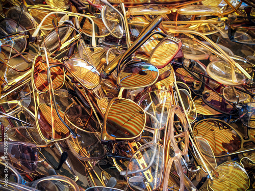 Sunglasses in different styles and colors piled together in a market setting