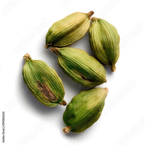 A close-up photo of several green cardamom pods arranged on a white background