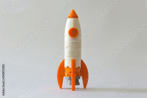 Orange and white plastic building block space rocket toy standing upright back view isolated on clean white background