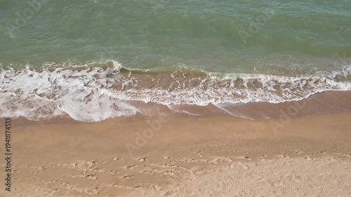 sea surf on sandy beach, top view, slow motion
