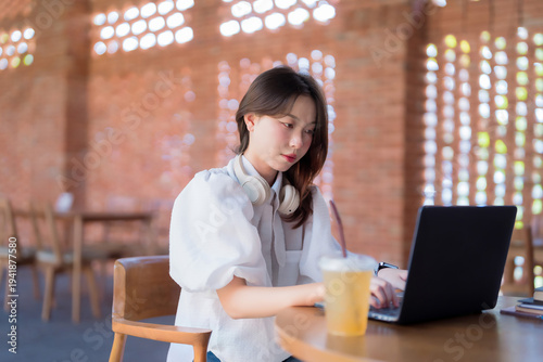 Asian woman freelance professional remote work laptop computer modern cafe concentrating business education tasks online study