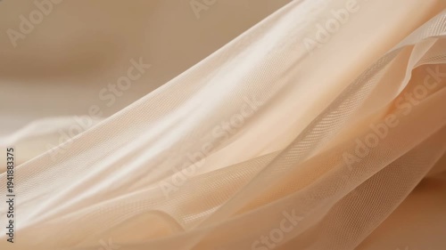 Soft beige fabric texture with delicate flowing translucent layers in gentle light