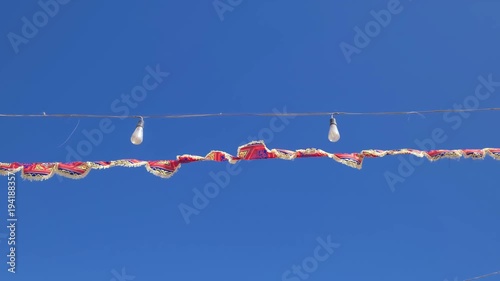 colorful holiday flags on ropes against sky, slow motion
